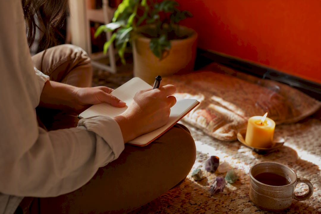 Hands writing intentions in a notebook