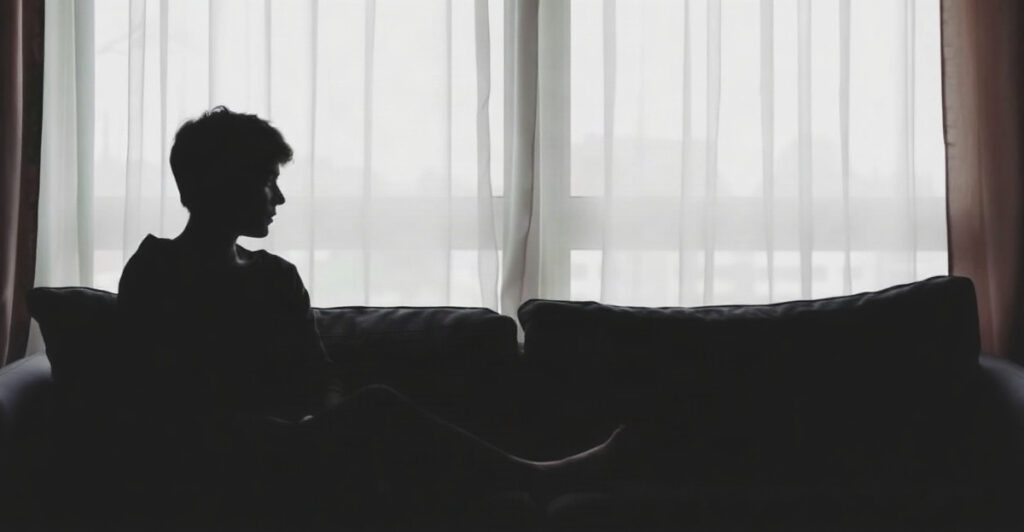 Silhouette by a window in grey morning light, a quiet image of having no motivation lately